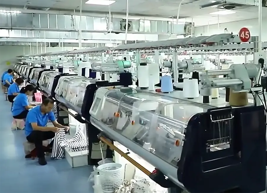 Rows of flat knitting machines on a knitwear production floor.