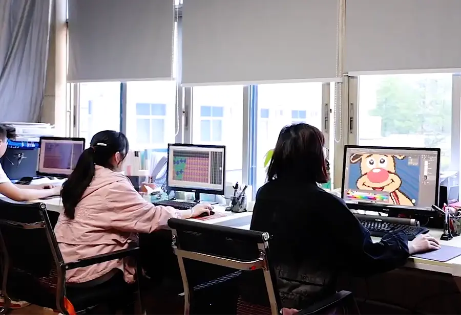 Knitwear artwork being prepared at computer workstations.